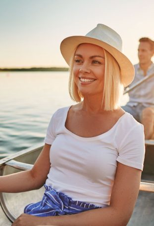 smiling-couple-paddling-their-canoe-on-a-lake-in-withperfect-veneers